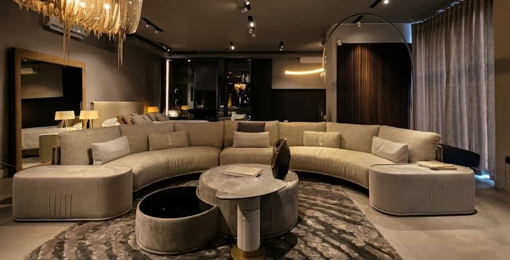 Luxurious living room with curved sofa and statement chandelier.