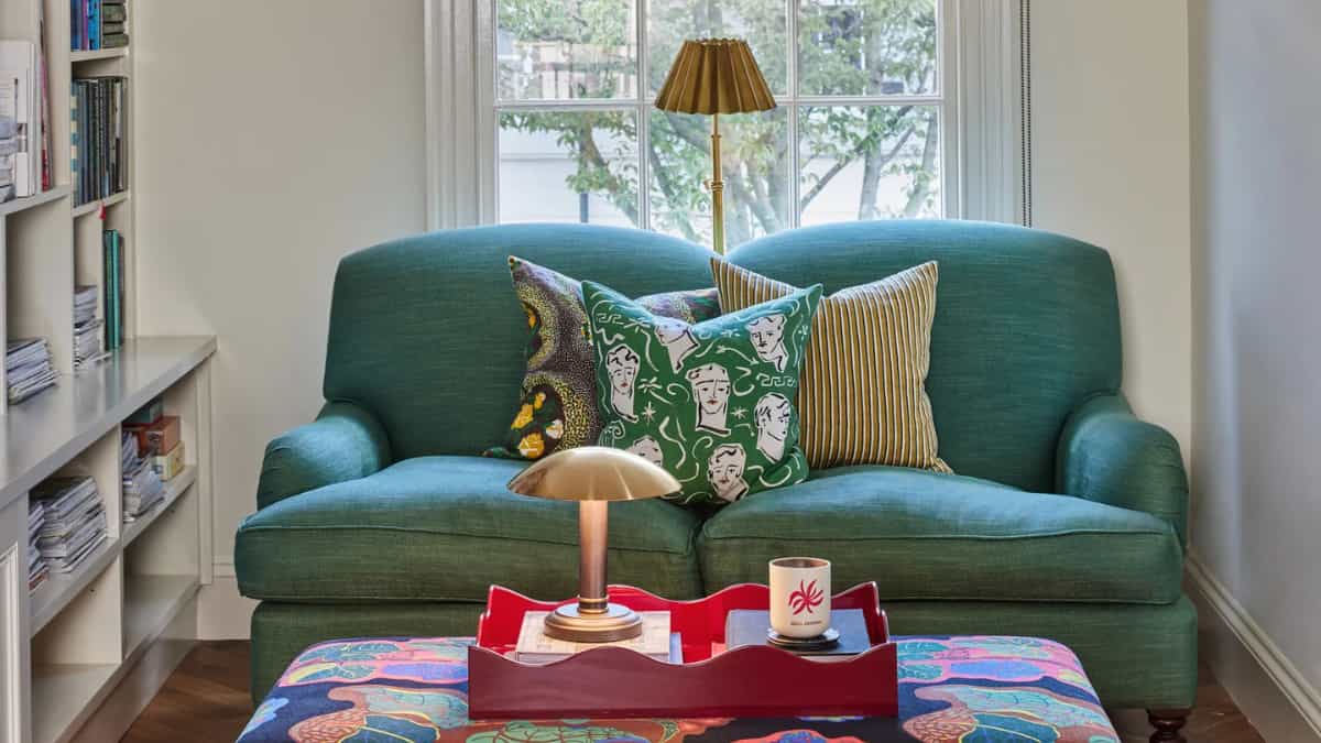Green sofa reading corner with patterned cushions, designed by Charlotte Save