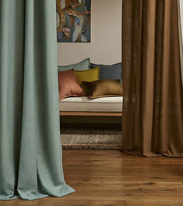 Contemporary living space with Villanova curtains and decorative cushions.