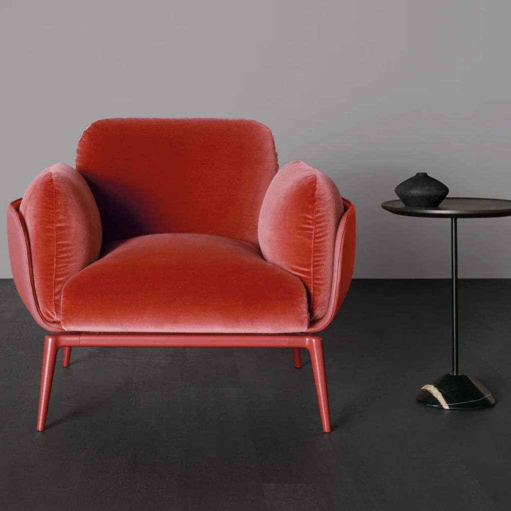 Amura armchair with a bold red hue and minimalist side table.