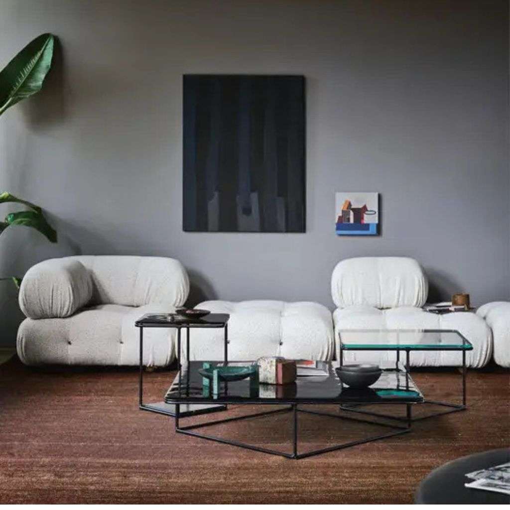 B&B Letti lounge area with curved, luxurious seating, contrasting against a muted wall.