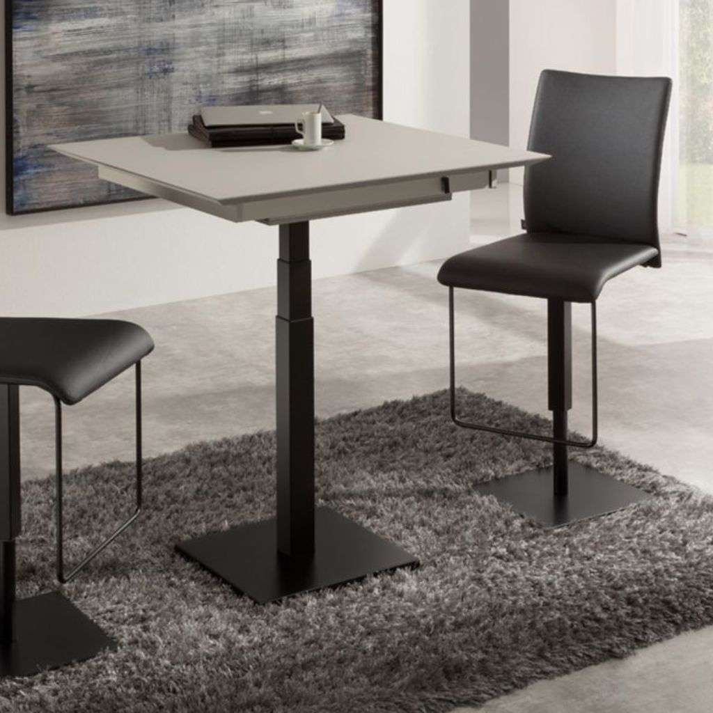 Bacher Tische square dining table with black chairs in a modern interior.