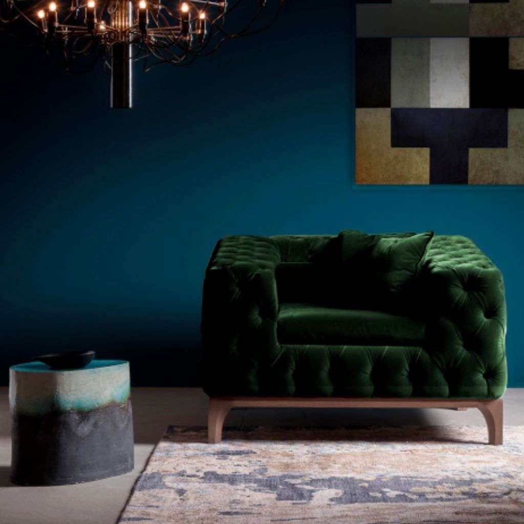 Bamax coffee table with a stylish design, featuring a tufted green armchair and a statement chandelier.