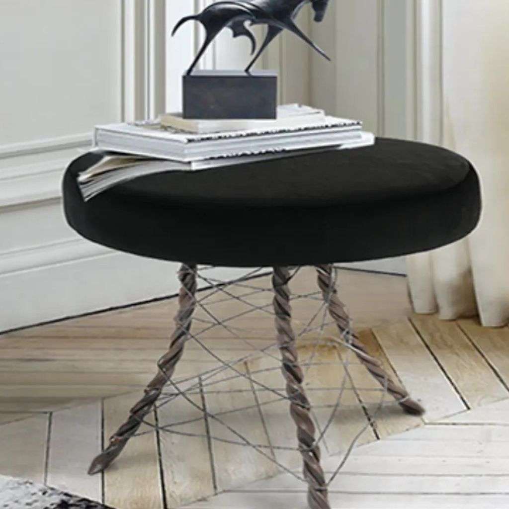 Round black Bateye stool with twisted metal legs in modern interior.