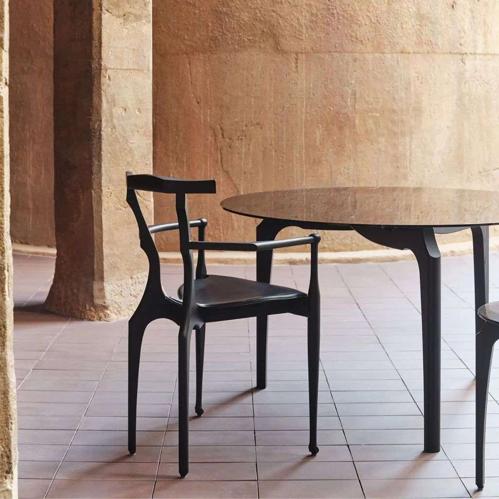 BD Barcelona black chair and table in a rustic space.