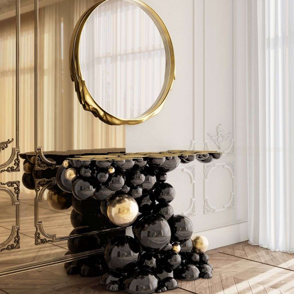 Boca do Lobo sculptural console table with circular mirror and gold detailing.