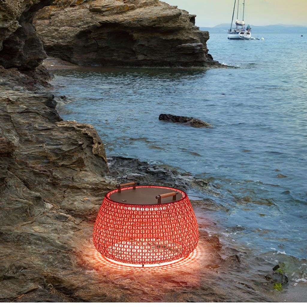 Bover outdoor tables with built-in lighting, set against a scenic ocean view.