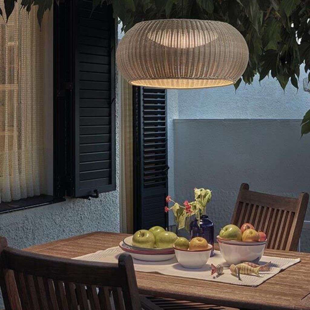 Bover hanging light fixture adding warmth to an outdoor dining area.