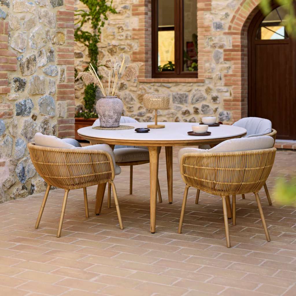 Cane-line Aspect dining table with Stay chairs in rustic courtyard.