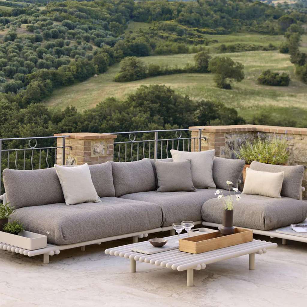 Cane-line modular outdoor sofa on stone terrace with valley view.