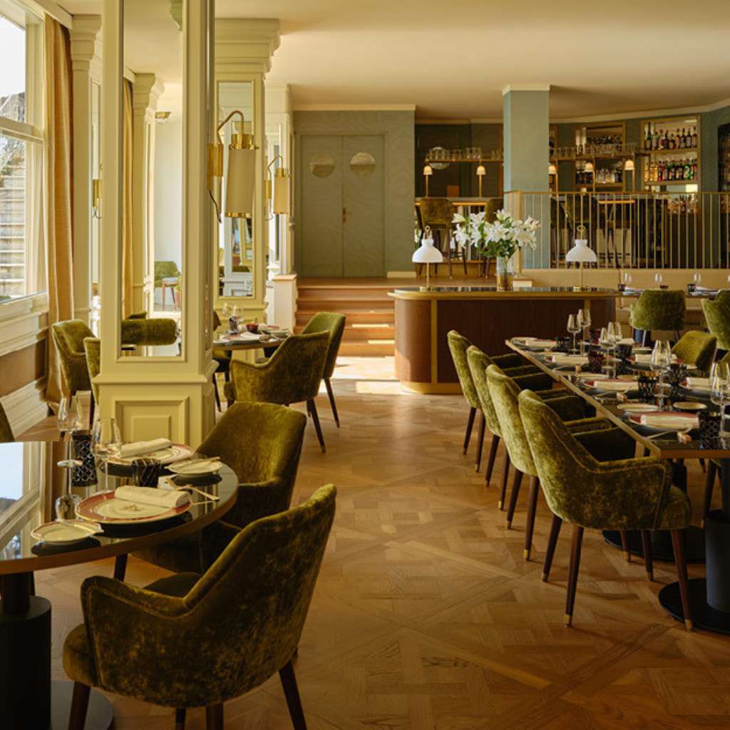 dedar-designed restaurant interior featuring rich velvet chairs and gold accents.
