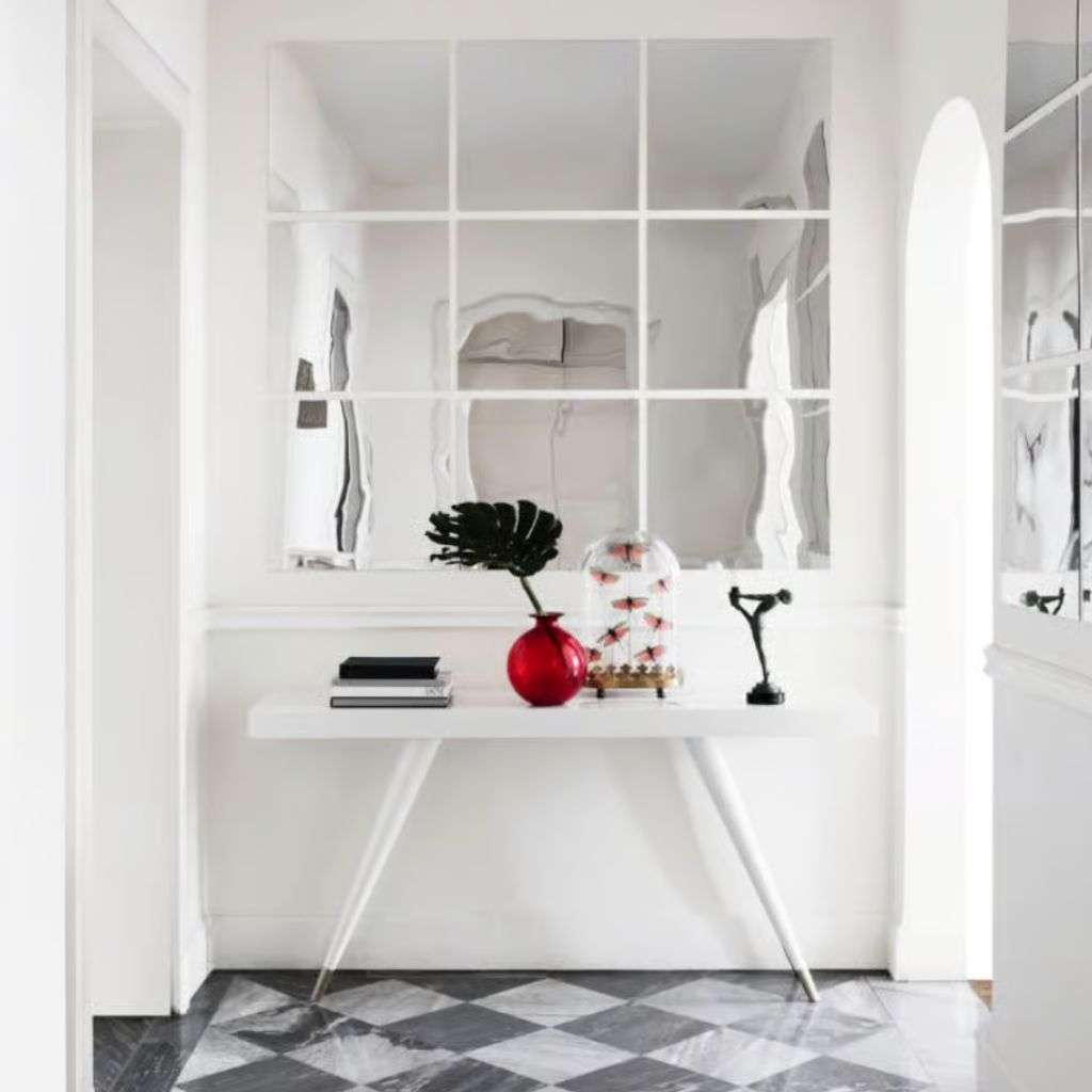 Dom Edizioni: Sleek entryway design with modern marble flooring and striking mirrored wall.