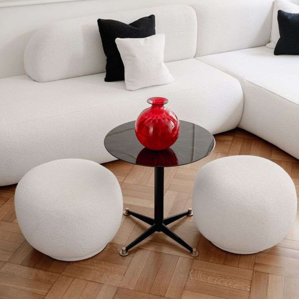 Bold coffee table with red vase and black and white seating by Dom Edizioni.