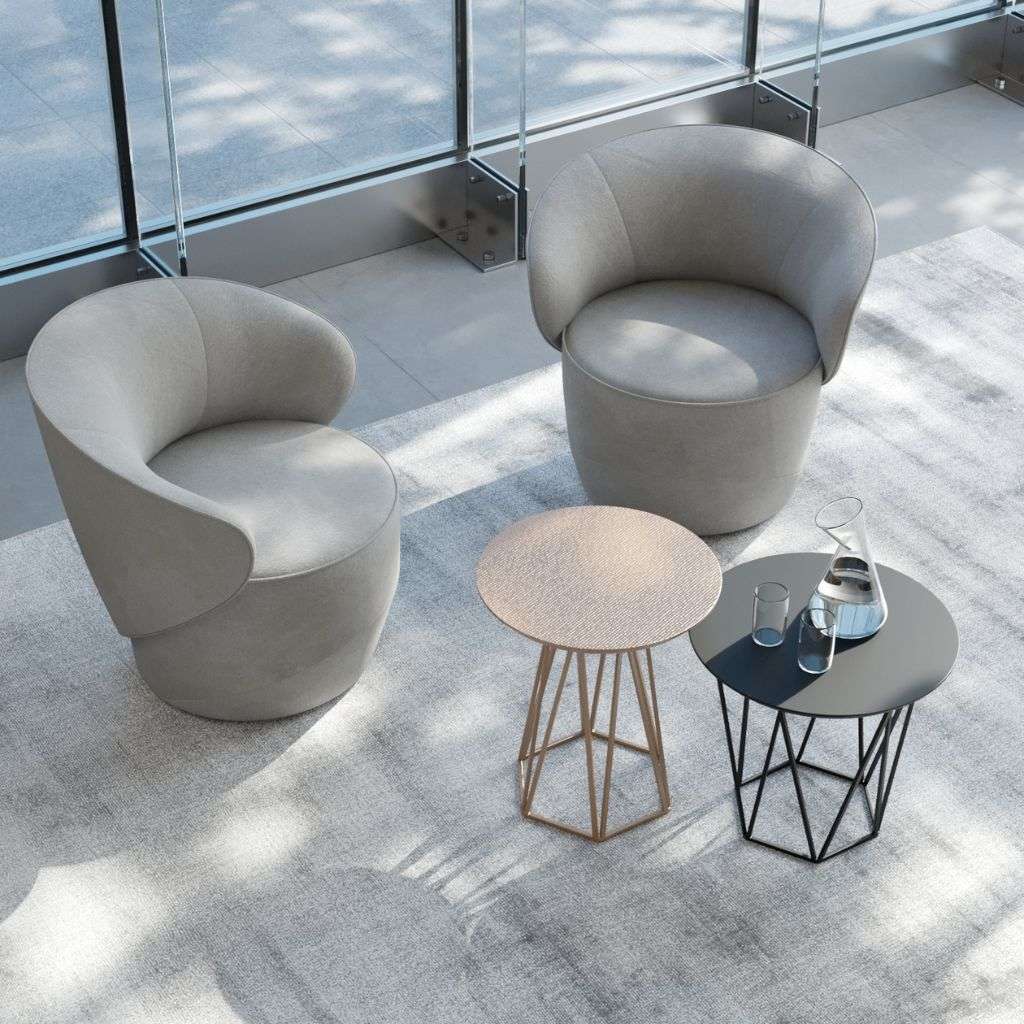 Emmebi grey tub armchairs with round accent tables on a light rug, airy setting.