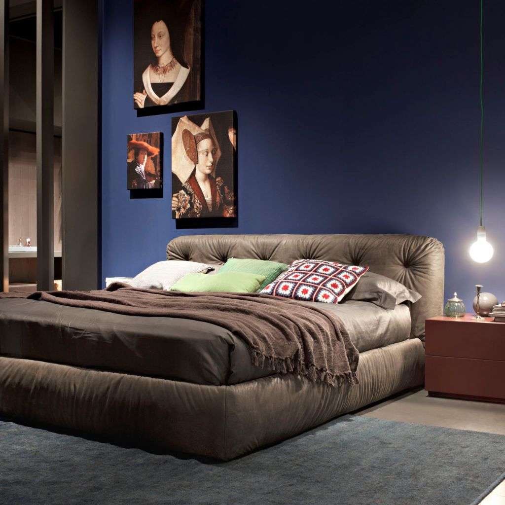 Emmebi tufted upholstered bed in leather, styled with navy wall art and pendant light.