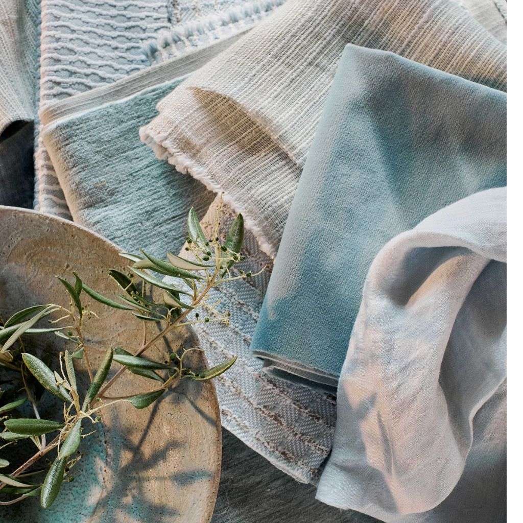 Evitavonni fabric swatches and cushions in earth tones for bespoke designs.