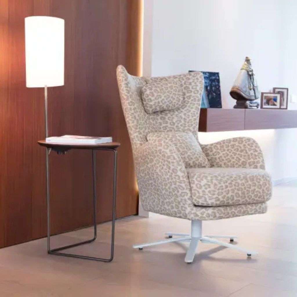 Fama's elegant leopard-print armchair combines luxurious design with functionality.