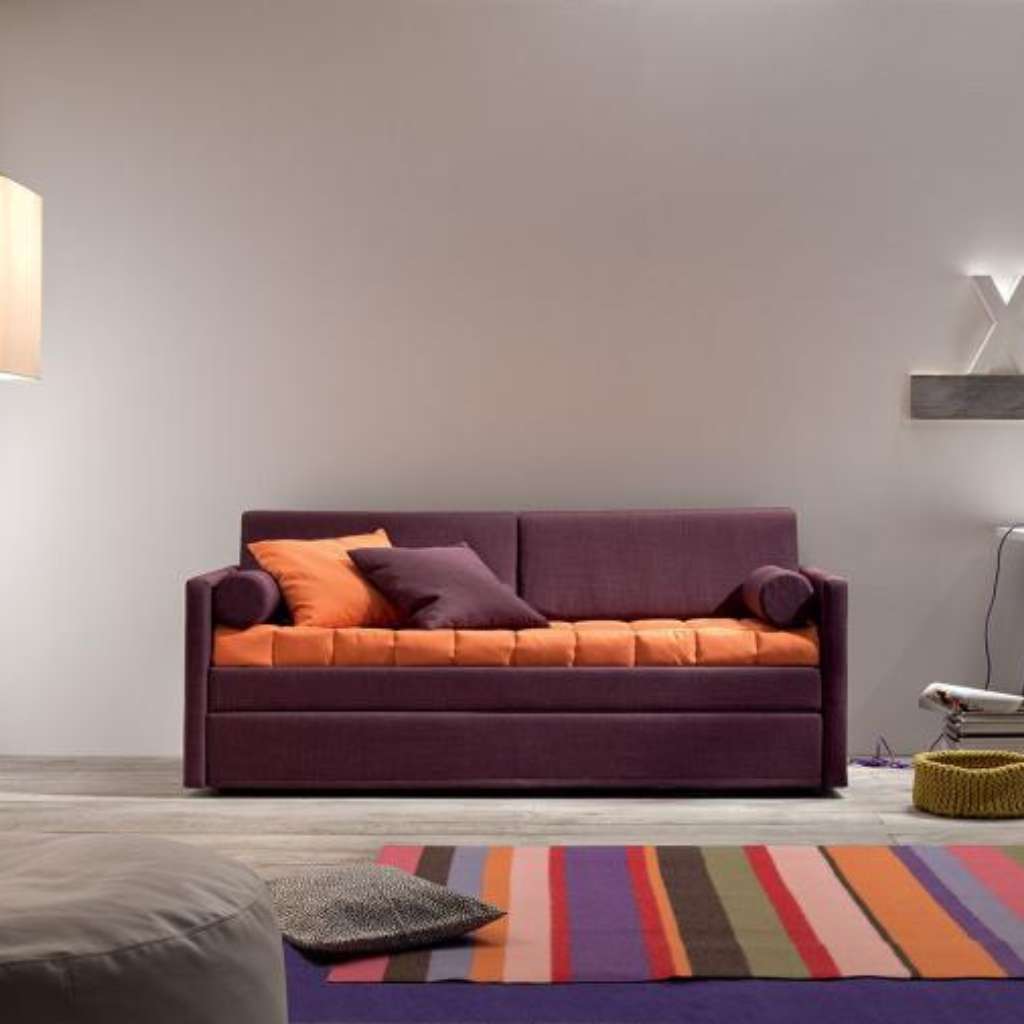 Felix vibrant sofa in purple with orange cushions, set in a cozy modern room.