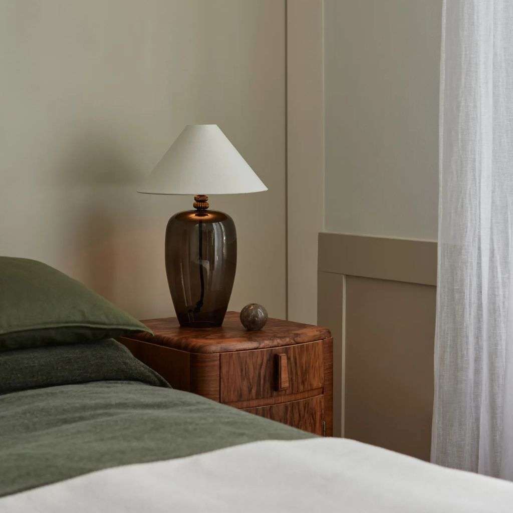 Heathfield dark glass bedside lamp with white shade in a calm neutral bedroom