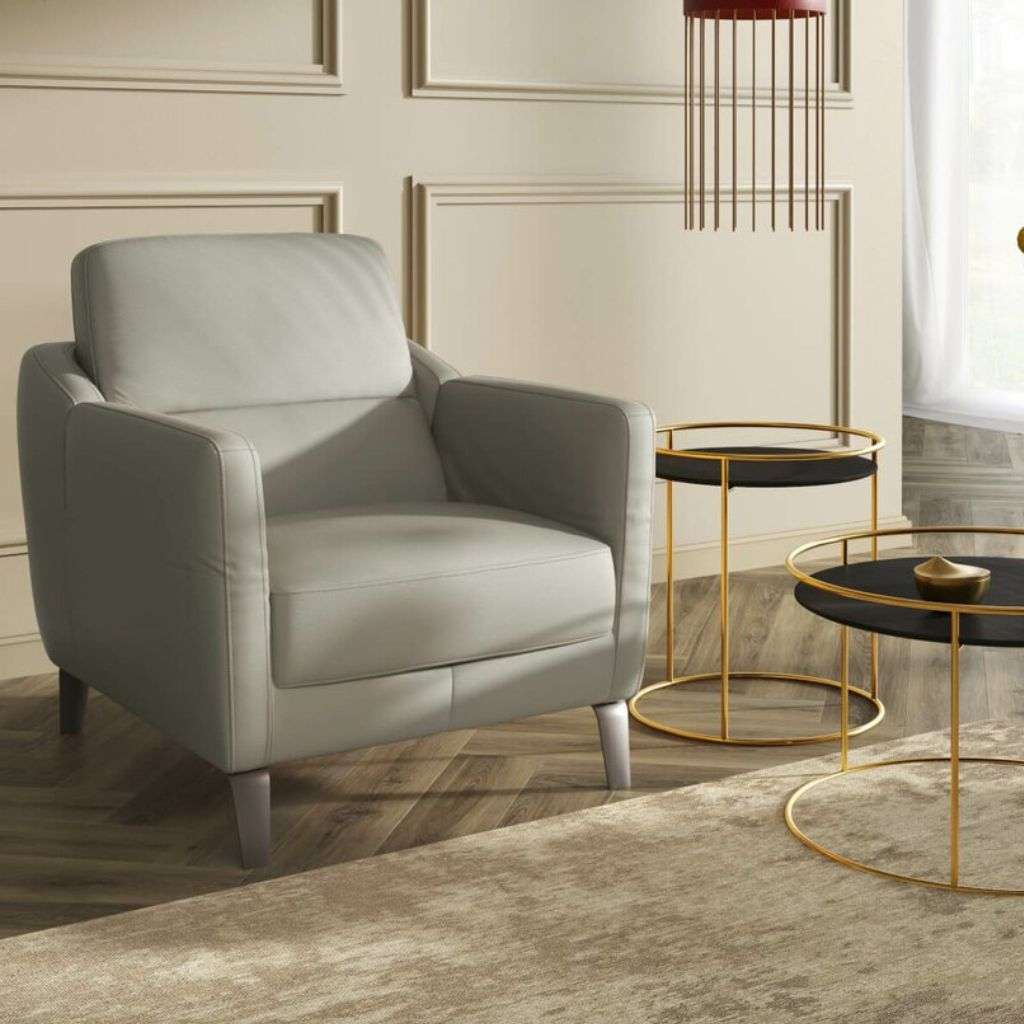Kler’s stylish grey armchair with round black side tables, offering a modern, luxurious vibe.