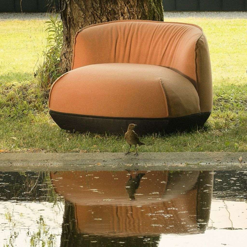 Kristalia outdoor lounge chair by a serene pond, blending comfort and nature.