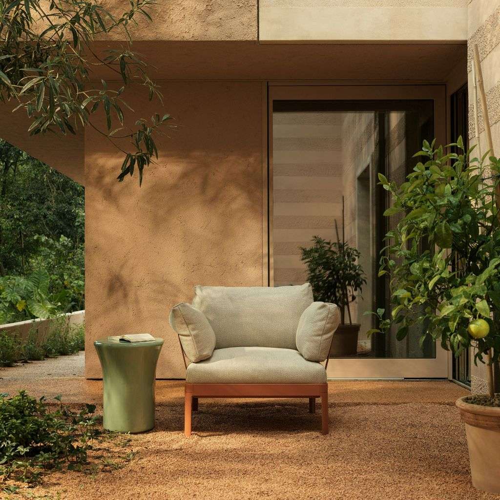 Kristalia armchair in a stylish outdoor patio setting with natural elements.