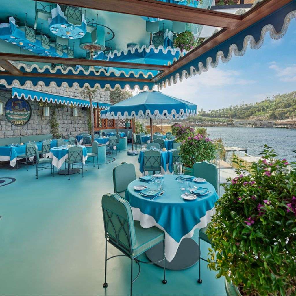 La Fibule outdoor dining with turquoise accents and elegant table settings.