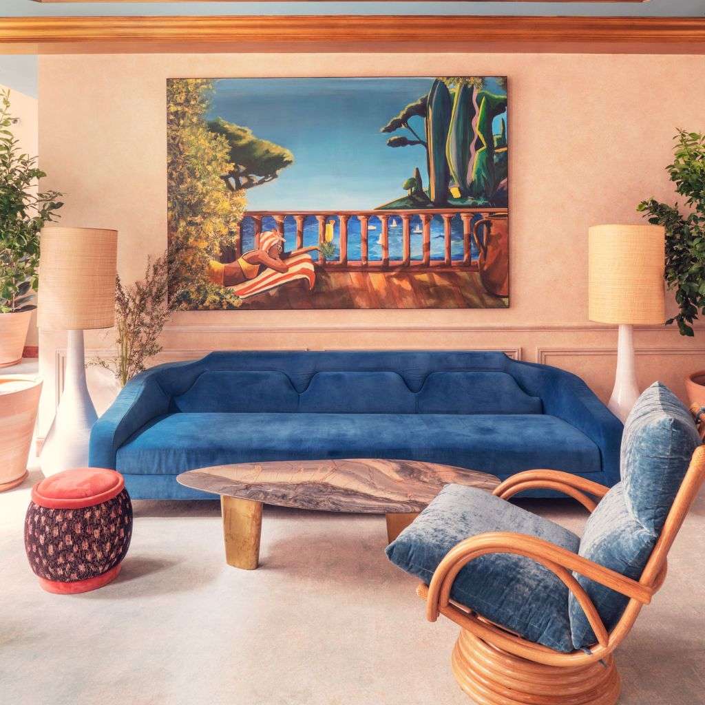 La Fibule living room with bright blue furniture and a bold landscape painting.