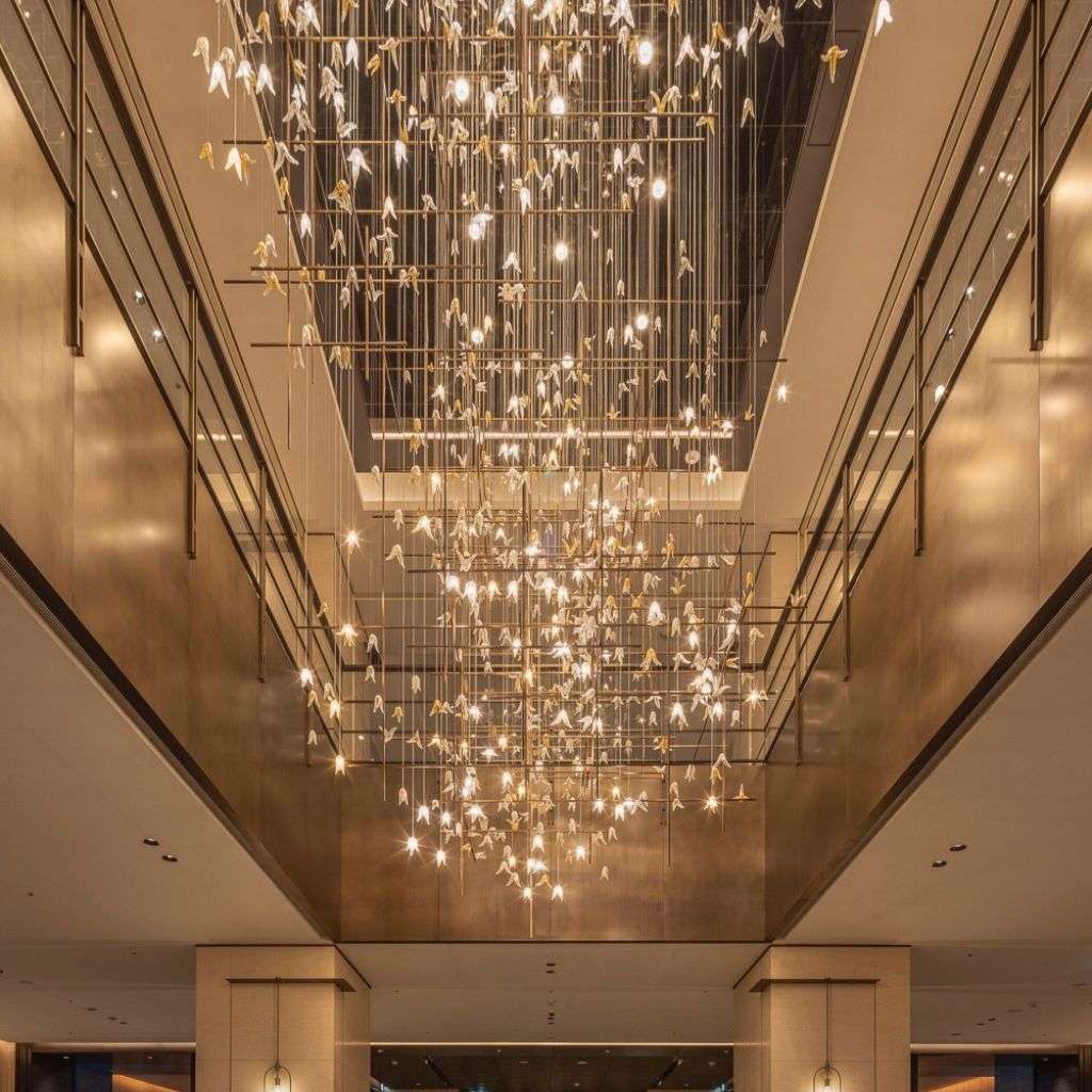 Lasvit grand cascading chandelier installation in a double-height lobby.