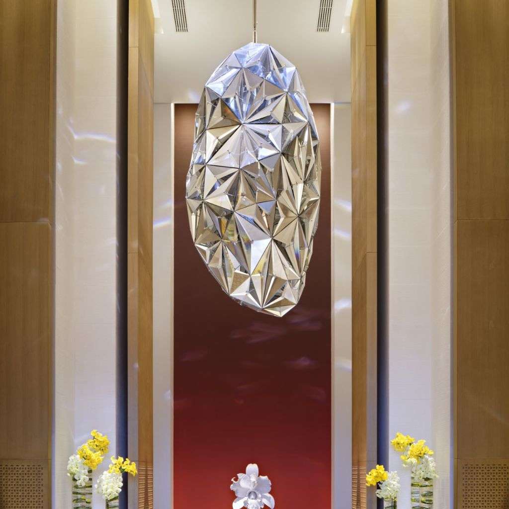 Lasvit faceted crystal-look pendant as a dramatic lobby centrepiece.