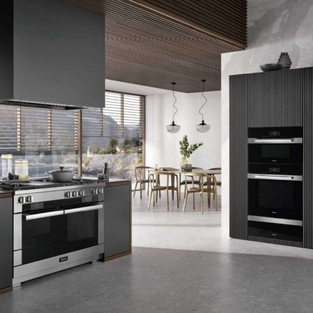 Miele ovens in a contemporary kitchen with large range cooker and dining area.