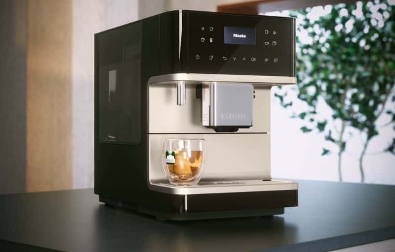 Miele countertop coffee machine brewing espresso in a sleek modern kitchen.
