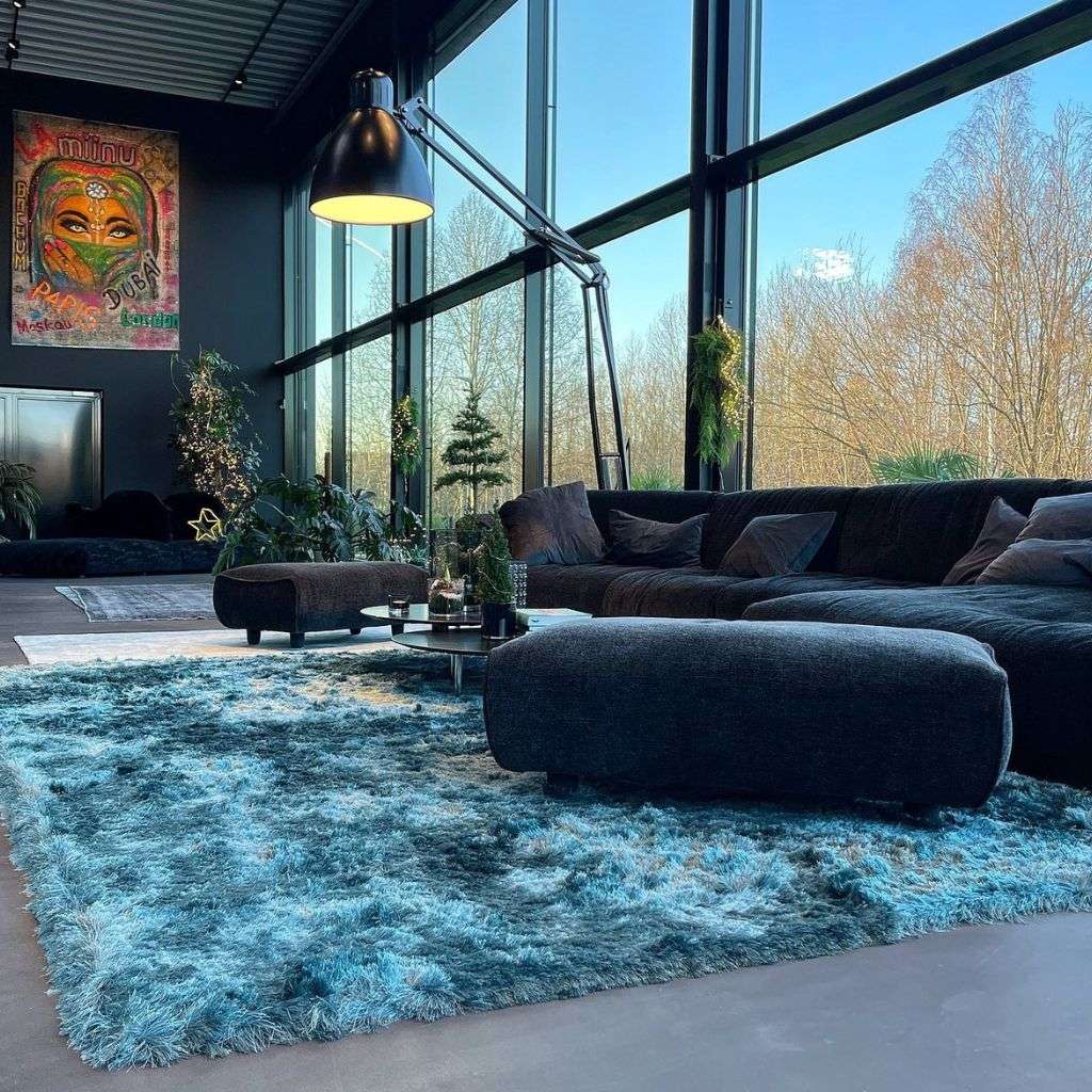 miinu shaggy teal rug adding luxe texture to a loft lounge with charcoal sofa and ottoman.