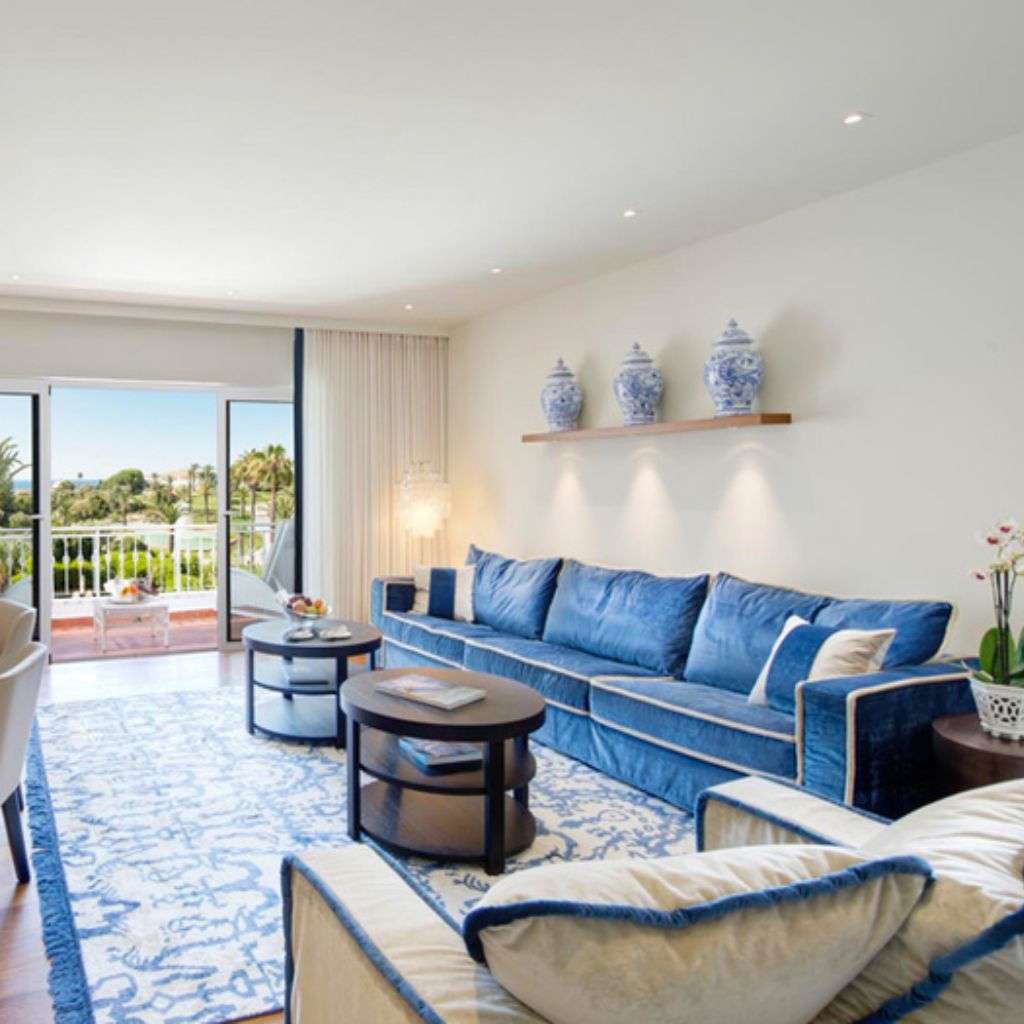 miinu blue and white rug elevating a coastal lounge with velvet sofa and chinoiserie accents.