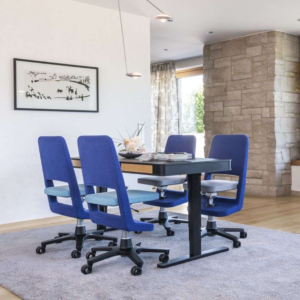 Bold blue office chairs and table in modern workspace by Moll.