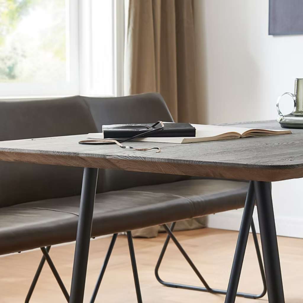 Nou elegant dining table with a natural wood top and sleek black legs.