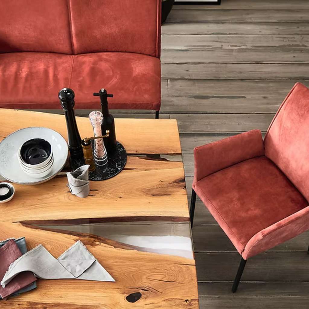 Nou modern dining setup with velvet chairs and artistic wooden table.