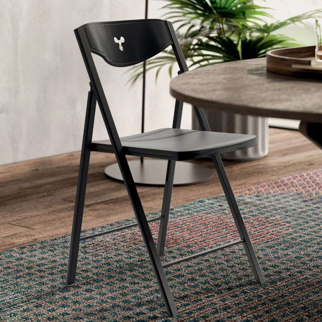 Ozzio Italia foldable chair with sleek black design, placed next to a stylish dining table.
