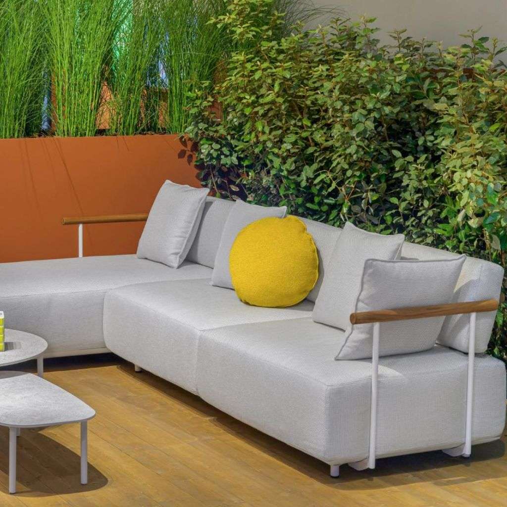 Pedrali outdoor seating arrangement with soft cushions and modern tables surrounded by plants.