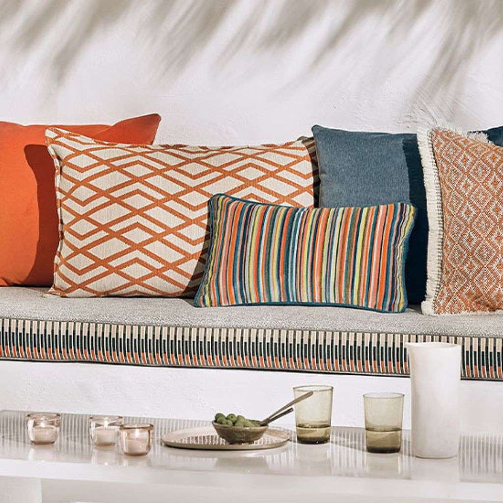 Romo cushions with geometric patterns and vibrant colors enhance this cozy setting.