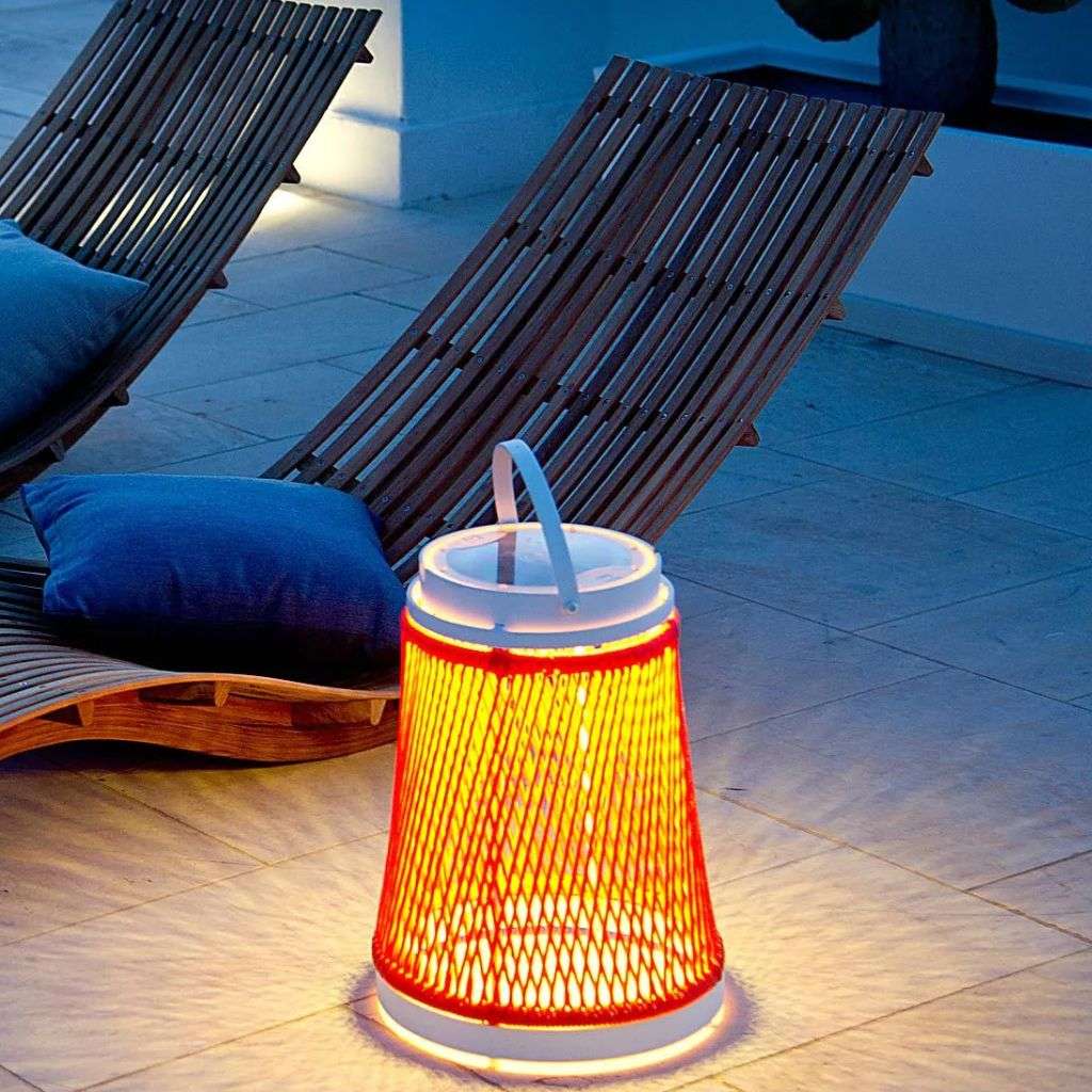 Outdoor lounge chairs with woven details and lantern by Unopiu.