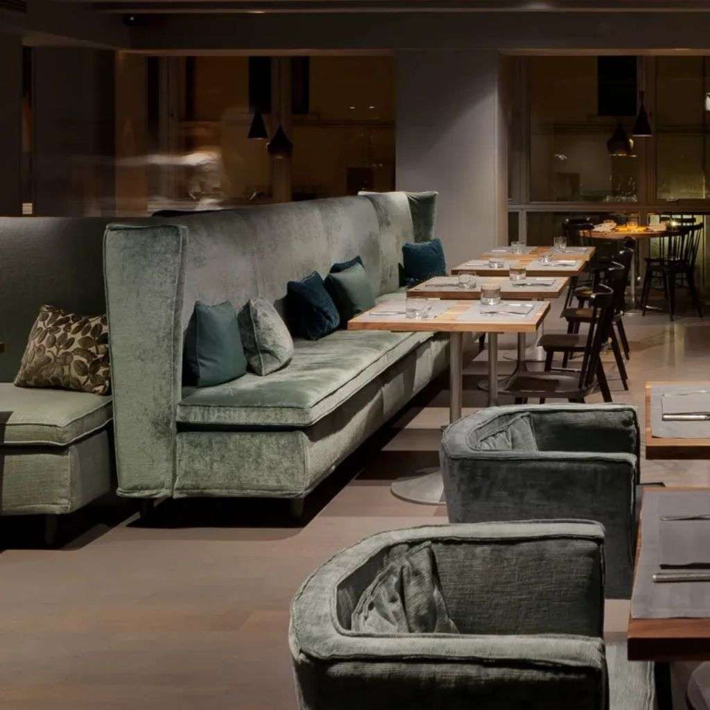Villevenete elegant seating area in a restaurant with plush, green velvet chairs and modern design