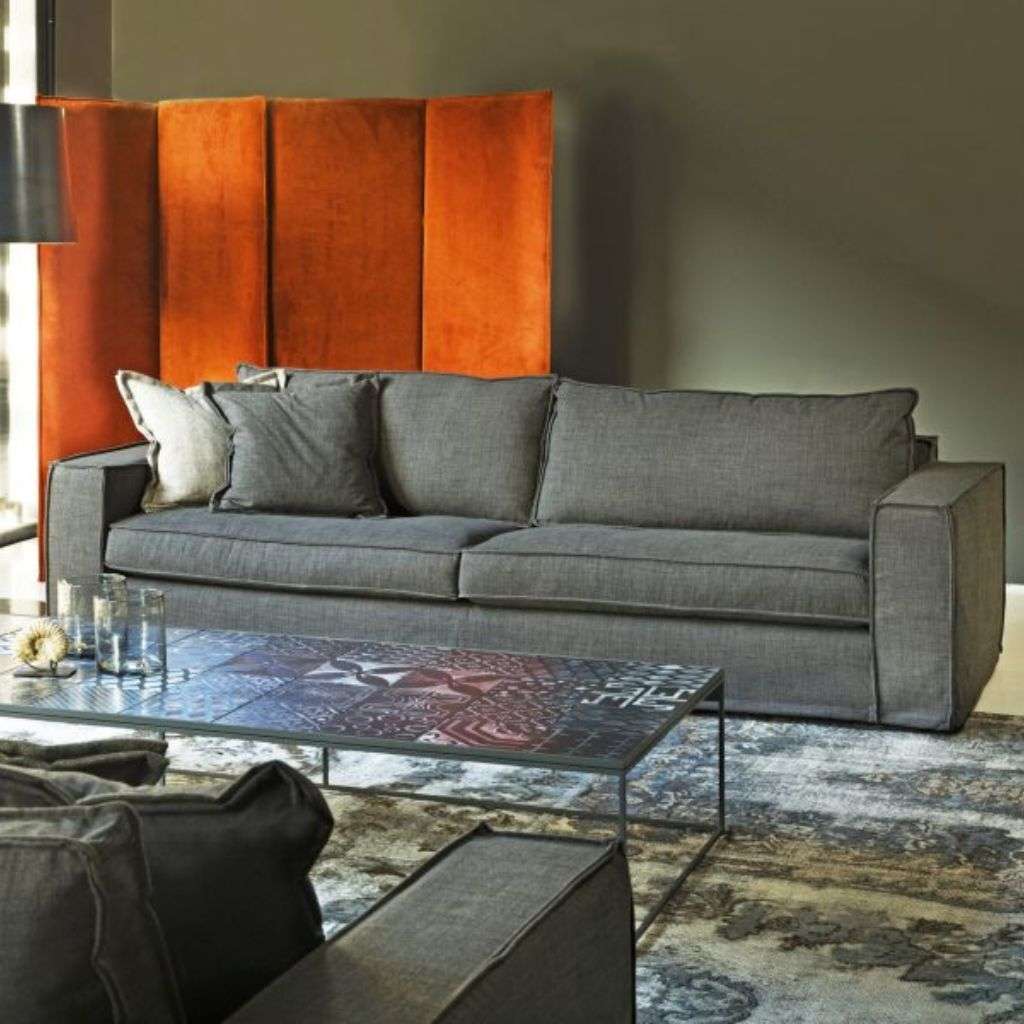 Villevenete modern grey sofa with contemporary style and a bold orange partition in the background.