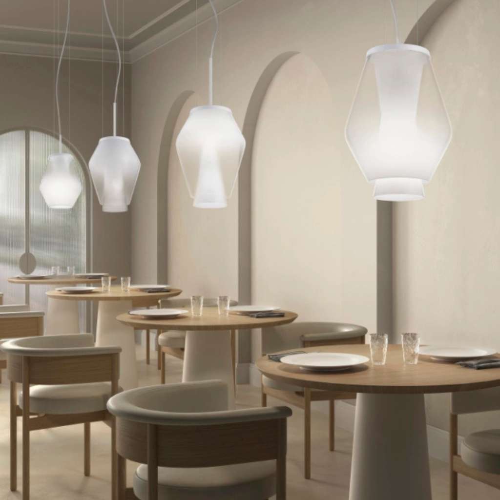 Vistosi frosted glass pendant lights hanging in a modern dining room, offering a refined glow.