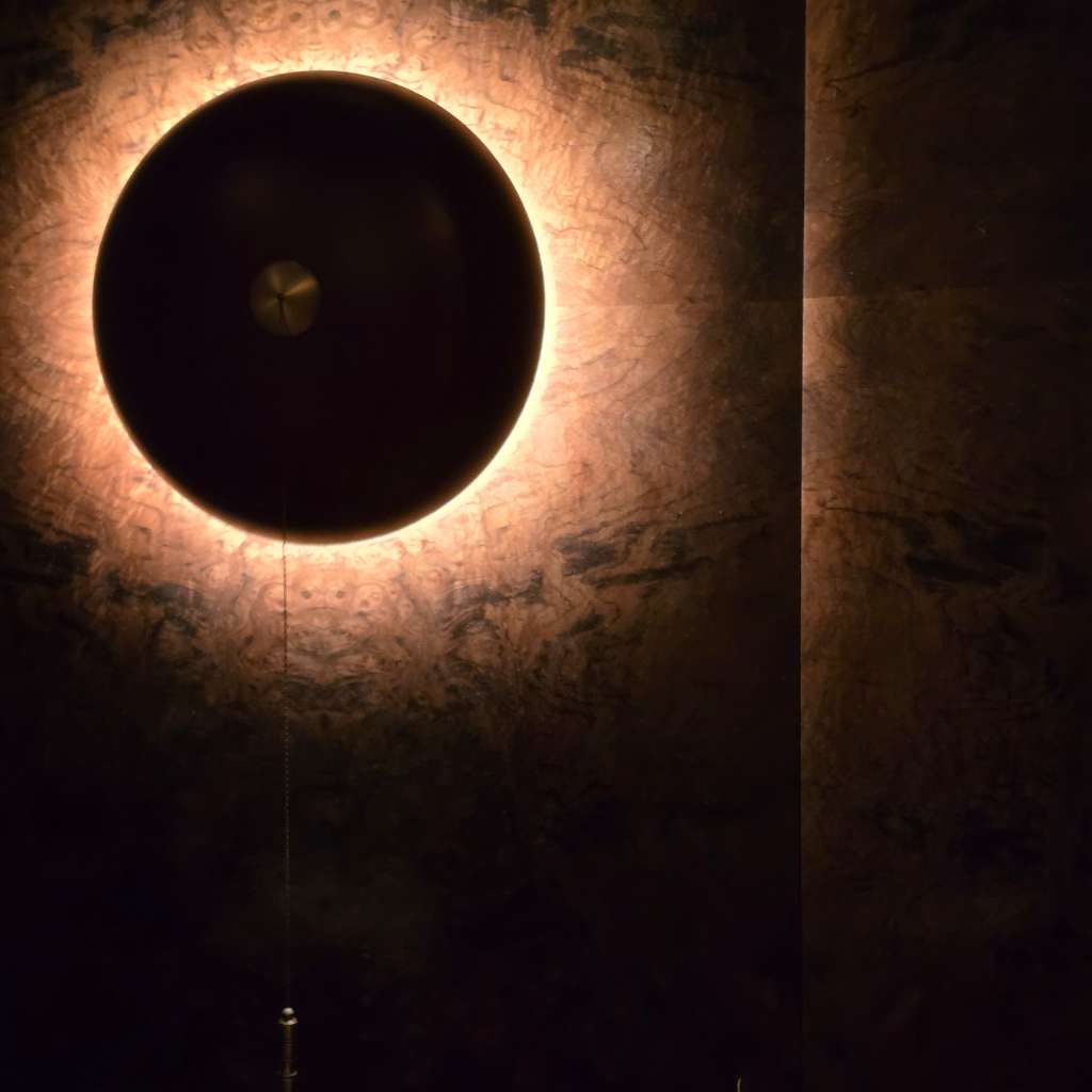 Art Deco circular wall light with warm glow on textured luxury walls