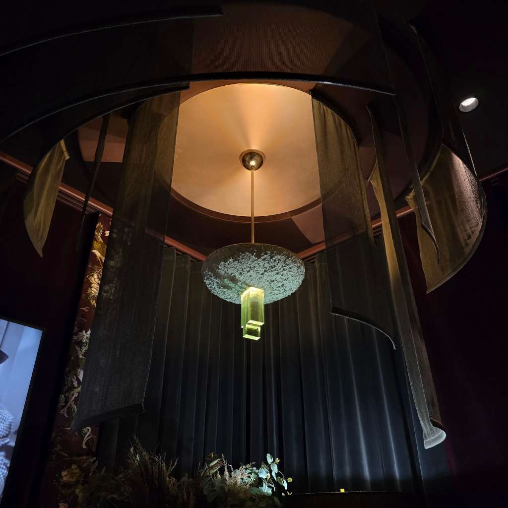 Sculptural ceiling design with floating fabric panels and statement pendant lighting