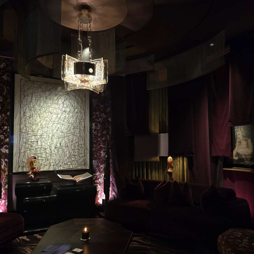 Circular luxury lounge with statement chandelier, drapery and bespoke furnishings