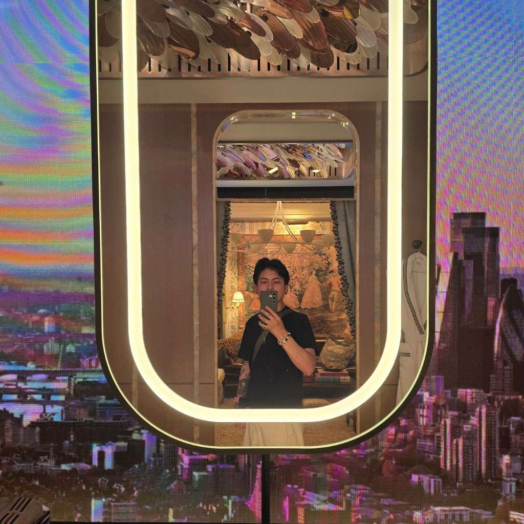 Interior designer photographing illuminated mirror in luxury bathroom suite