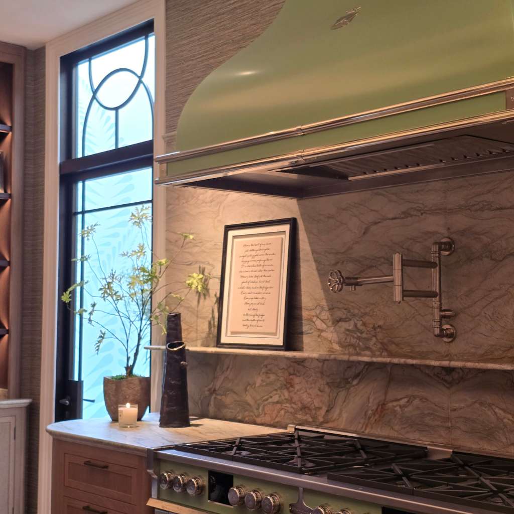 Bespoke kitchen joinery design with green range cooker hood, marble splashback and handcrafted cabinetry