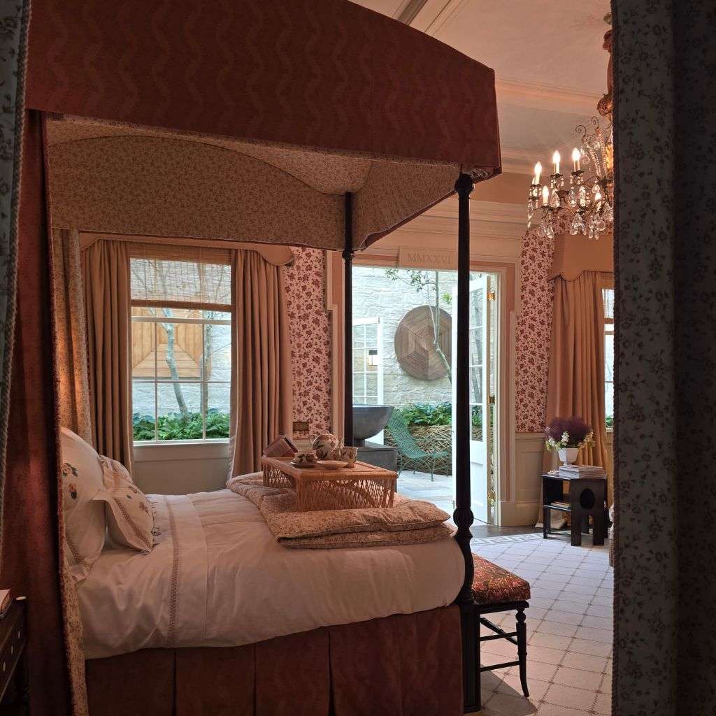 Luxury canopy bed with layered textiles and elegant traditional interiors
